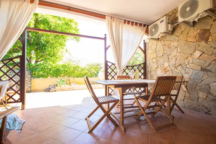 Patio con tavolo e muro in pietra