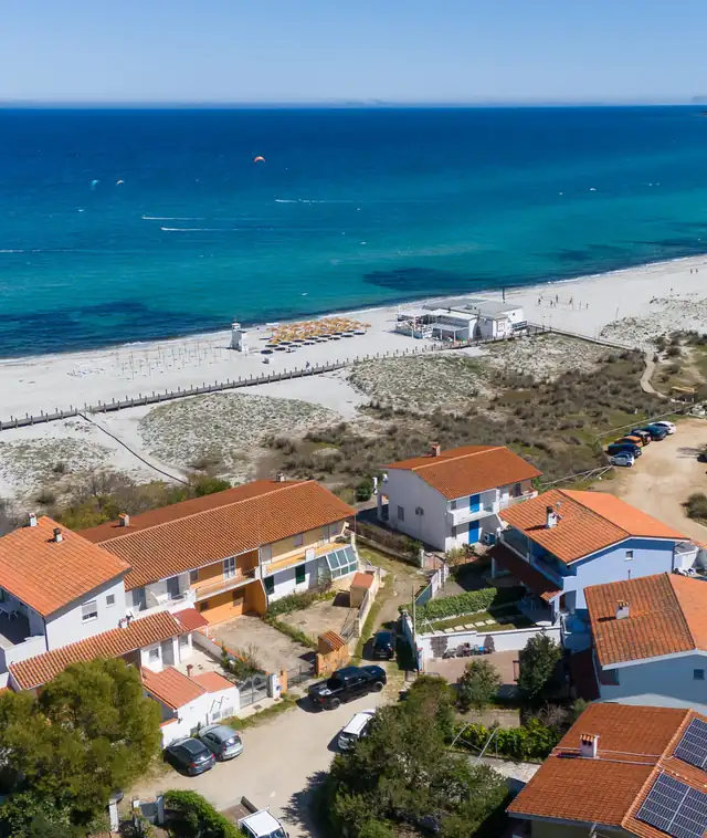 Case vacanza affacciate su una spiaggia bianca e sul mare turchese, ripresa dall’alto